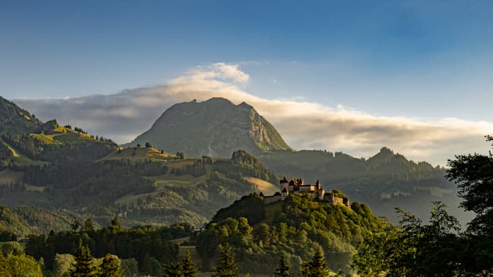 Vue depuis la terrasse sur le château de Gruyères et le Moléson au crépuscule